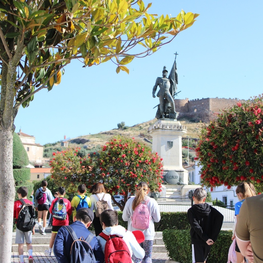 Plaza de Medellín, con visitantes y monumento en el centro.